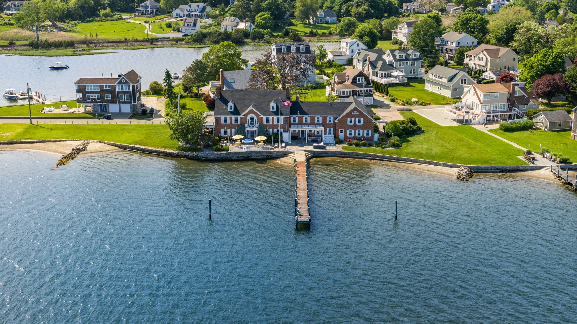 Aerial view of 30 Essex Street centered on the Mystic River waterfront with its pier extending from shore.